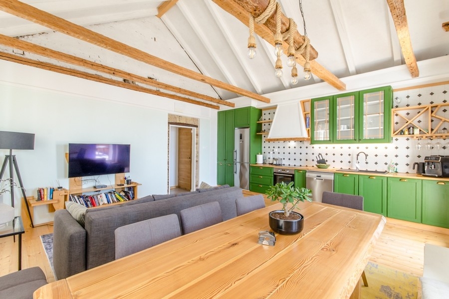 Obývací pokoj s otevřenou kuchyní a dřevěným trámovým stropem
