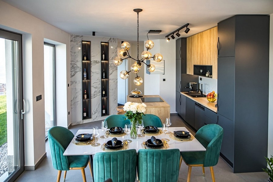 Jídelní kout s designovou lampou a otevřenou kuchyní