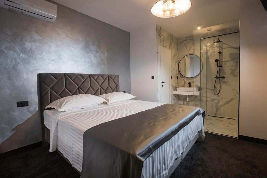 Ložnice s manželskou postelí a otevřenou koupelnou s en-suite