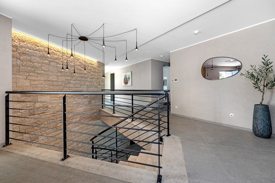 Galerie v horním patře s moderním zábradlím a designovými lampami