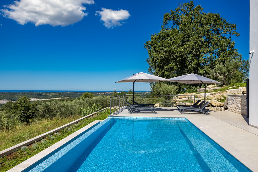 Prostorný bazén se sluneční terasou a výhledem na moře