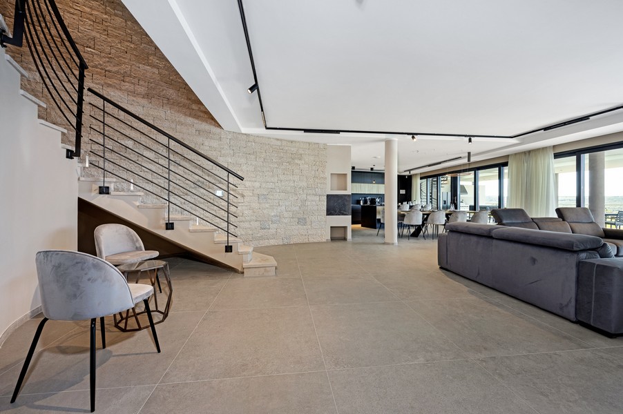 Otevřený obývací prostor se schodištěm a vysoce kvalitním nábytkem