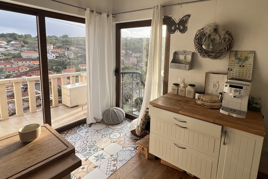 Kuchyňský kout s celoplošnými okny a přístupem na balkon