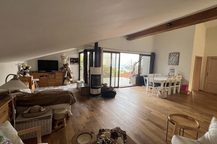 Otevřený obývací a jídelní kout s krbem a panoramatickými okny