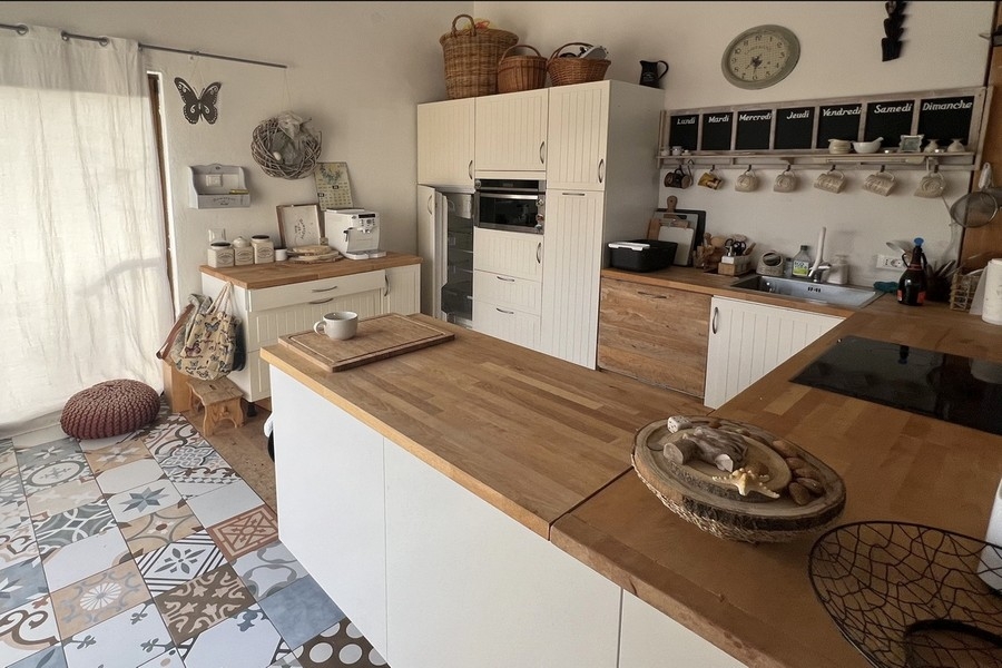 Moderní kuchyně s varným ostrůvkem a dřevěnou pracovní deskou