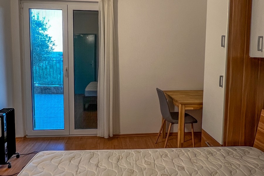 Ložnice se vstupem na balkon a psacím stolem