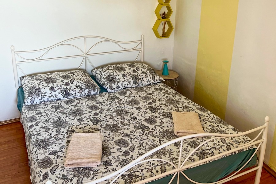 Ložnice s kovovou postelí a nočním stolkem