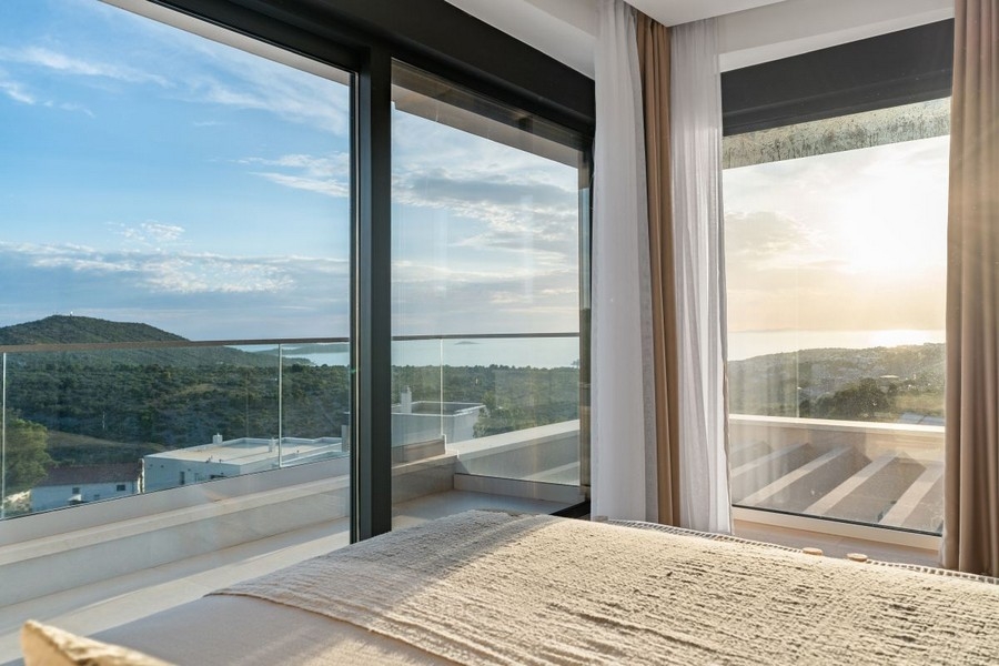 Ložnice s okny od podlahy ke stropu a panoramatickým výhledem na moře