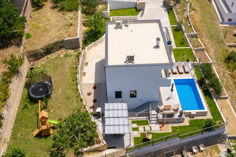 Letecký pohled na moderní vilu s bazénem a zahradou v Dalmácii