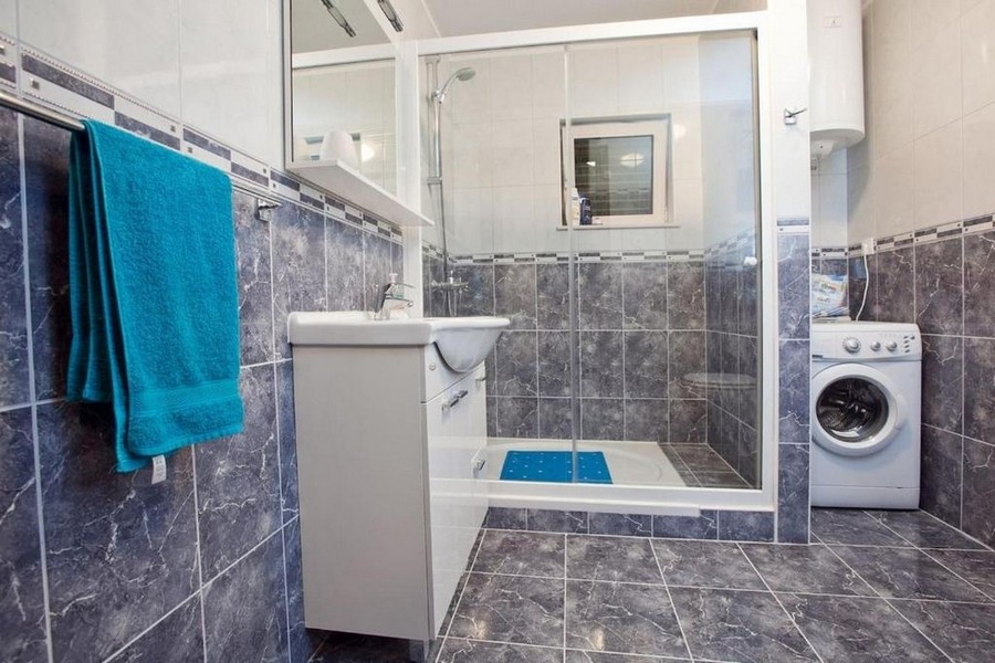 Koupelna se sprchovým koutem a pračkou