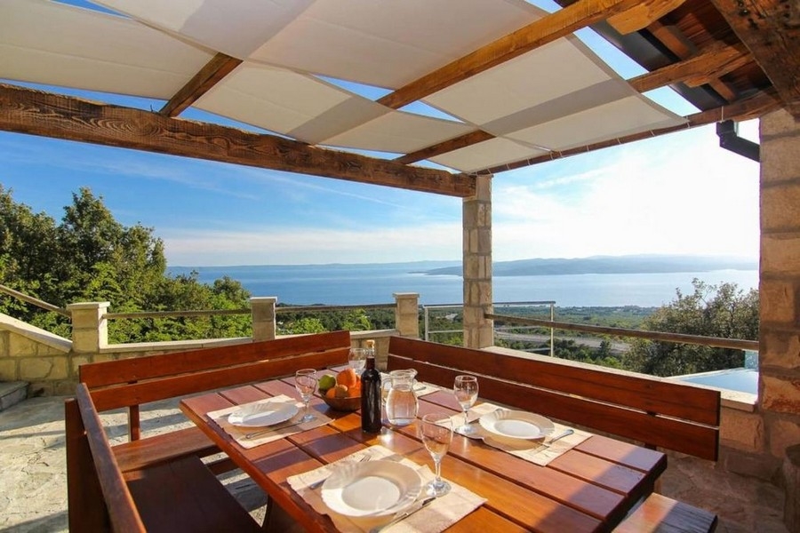 Krytá terasa s posezením a výhledem na moře