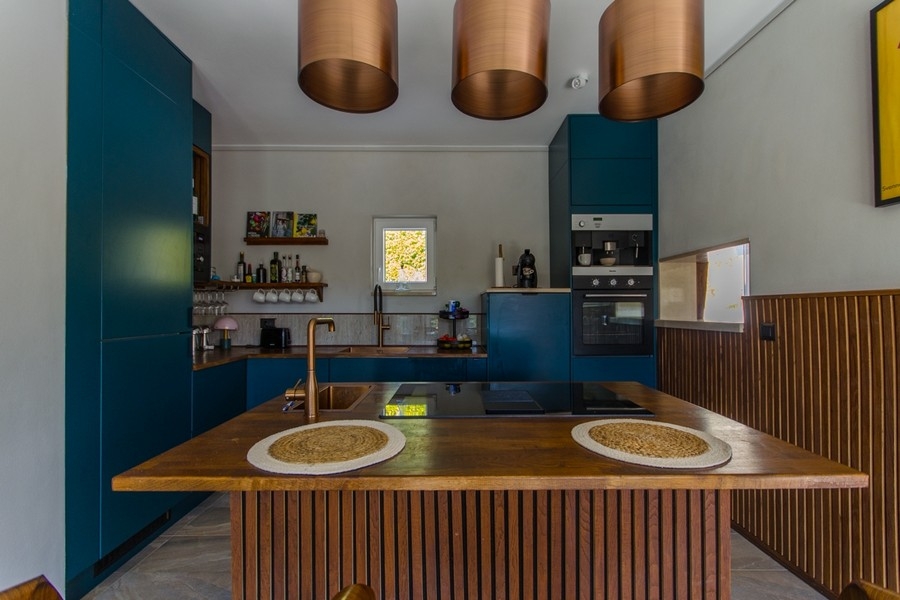 Kuchyně s ostrůvkem a měděnými lampami