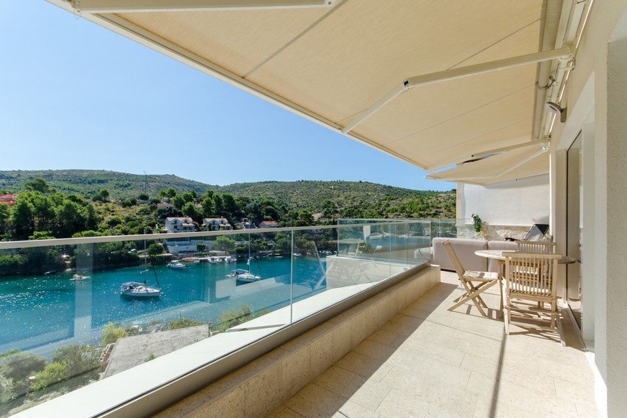 Balkon se skleněným zábradlím a výhledem na Bračský záliv