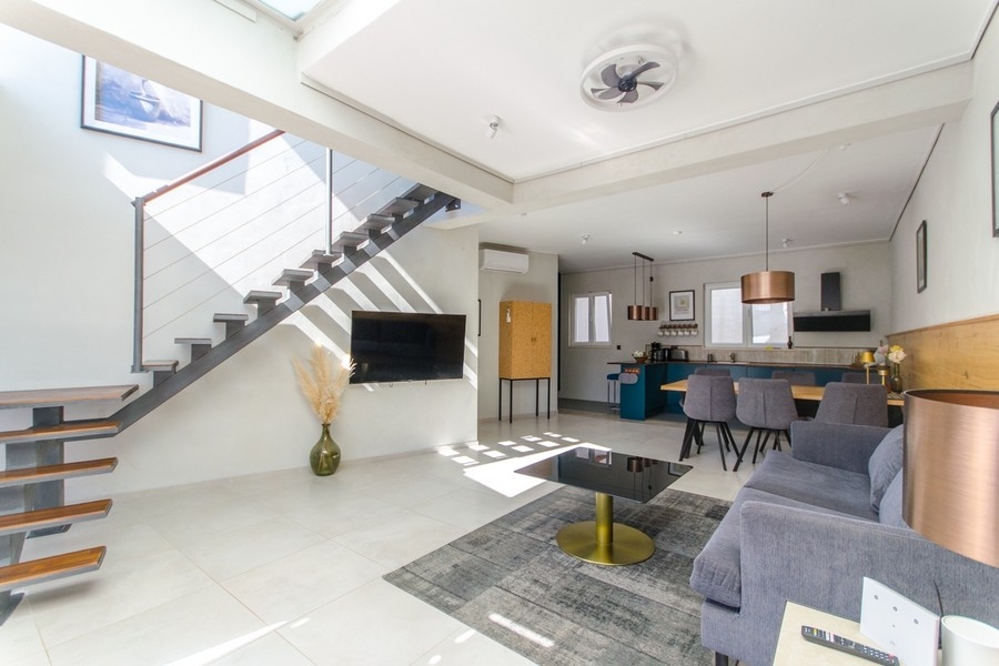 Moderní obývací prostor se schodištěm a otevřenou kuchyní