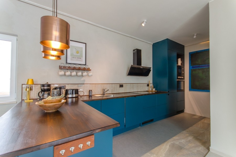 Moderní kuchyně s varným ostrůvkem a dřevěnou pracovní deskou