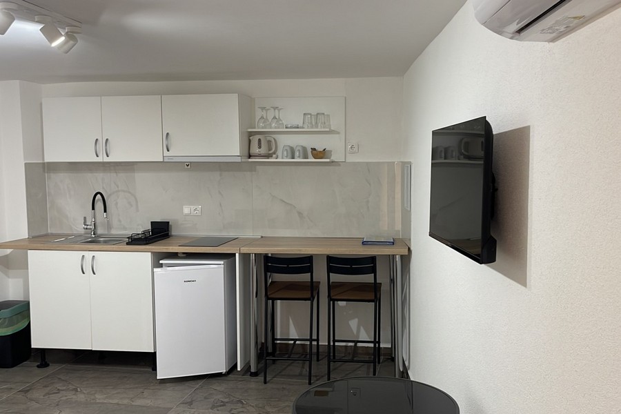 Kuchyň s barem a TV v apartmánu v Chorvatsku