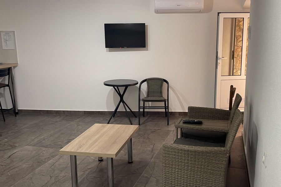 Obývací pokoj s křeslem a TV v apartmánu v Chorvatsku