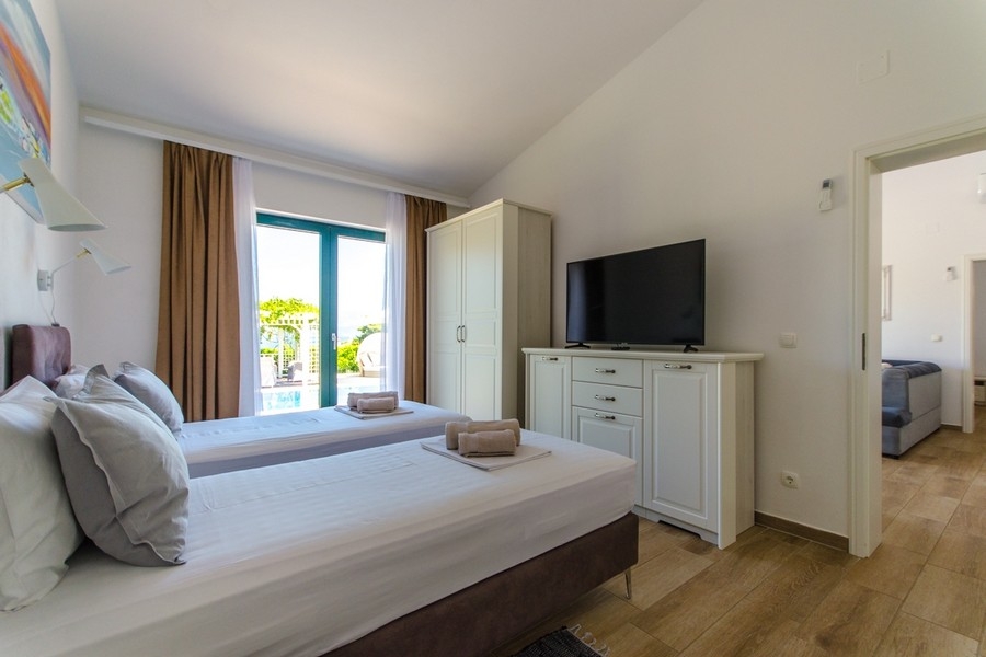 Ložnice se dvěma samostatnými lůžky a výhledem na terasu