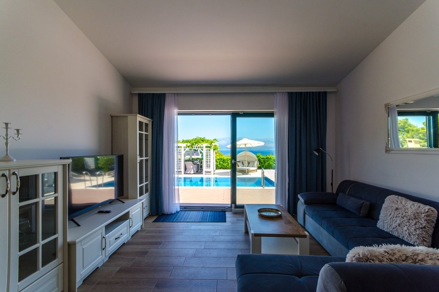 Obývací pokoj se vstupem na terasu a výhled na bazén