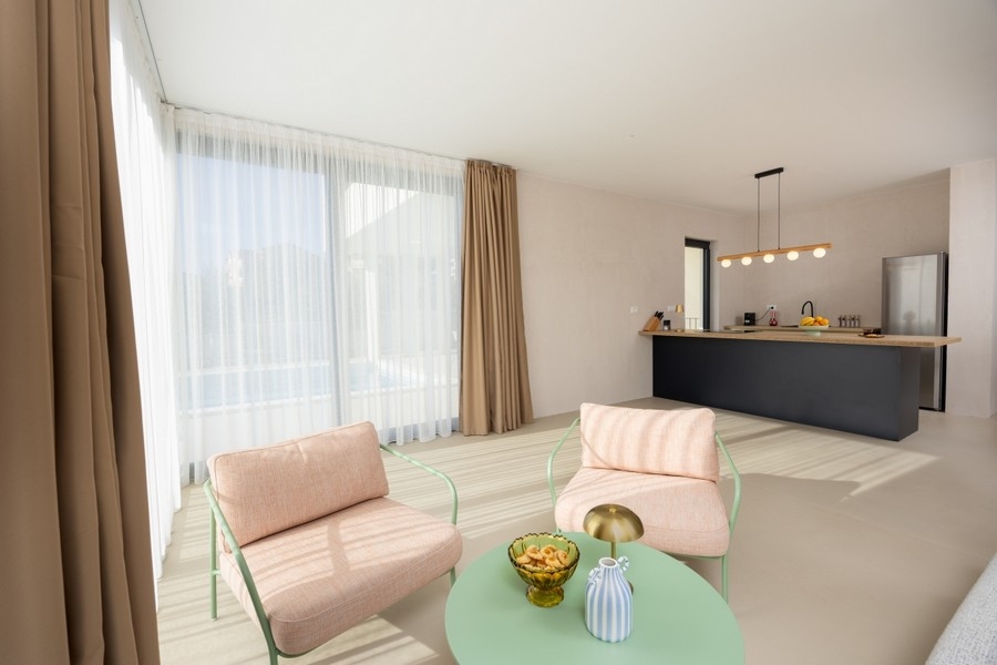 Otevřený obývací prostor s kuchyní a velkými okny