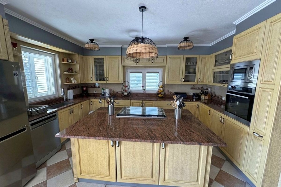 Otevřená kuchyně s jídelním koutem a přístupem na terasu s výhledem na moře