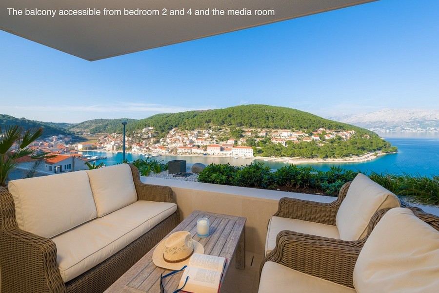 Krytý balkon s posezením a výhledem na záliv a město