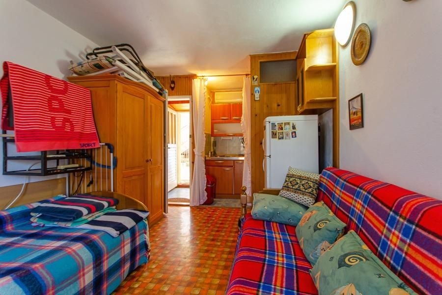 Obývací pokoj s pohovkou a malou kuchyní