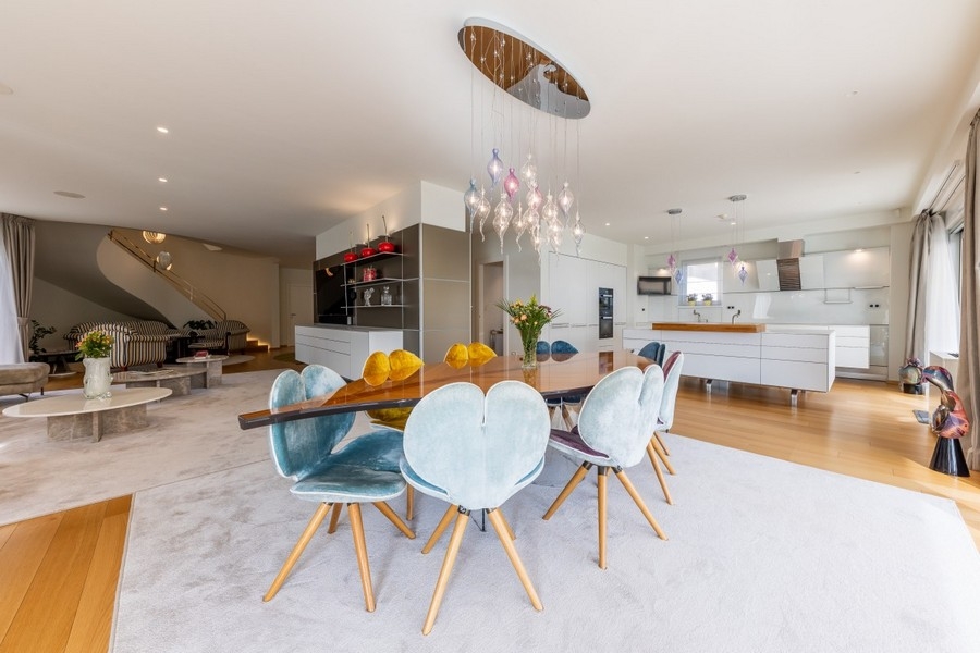 Otevřený jídelní kout s designovým osvětlením a moderní kuchyní