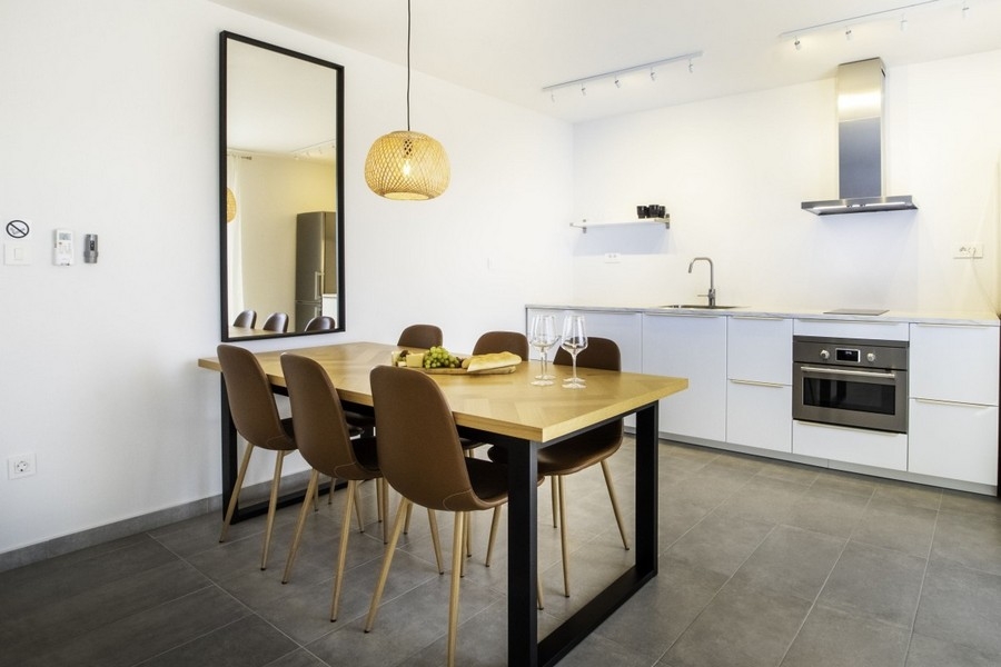 Otevřená kuchyně s jídelním stolem a moderně zařízenou kuchyní