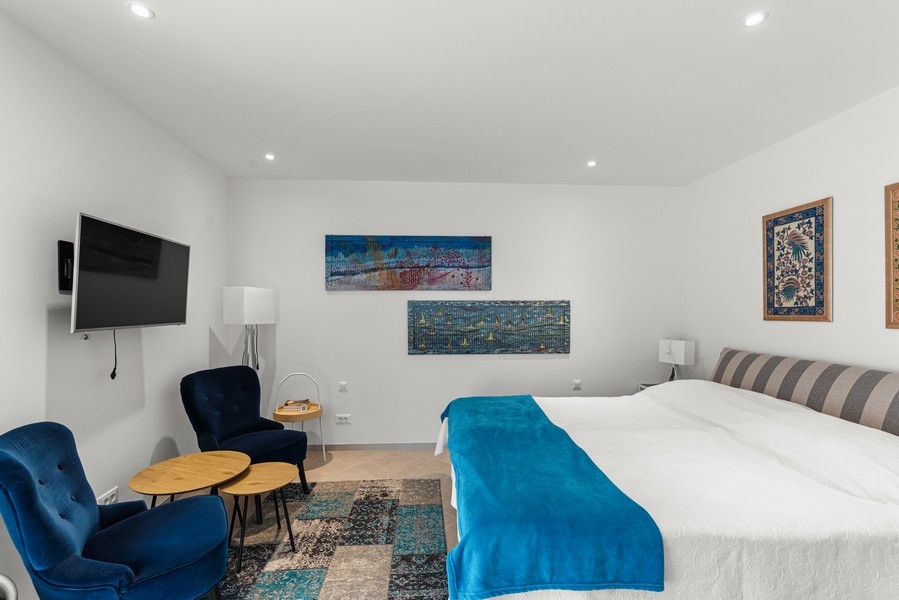 Ložnice s velkou manželskou postelí a posezením