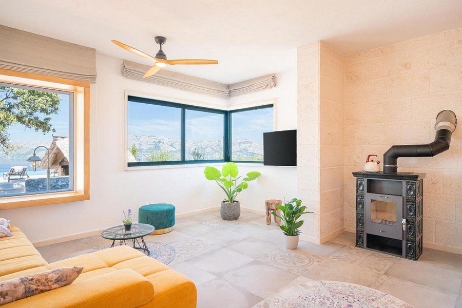 Světlý obývací pokoj s krbem a panoramatickými okny