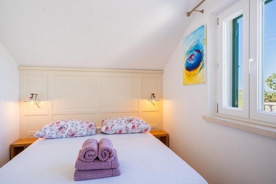 Ložnice s oknem a výhledem na moře v klidné lokalitě