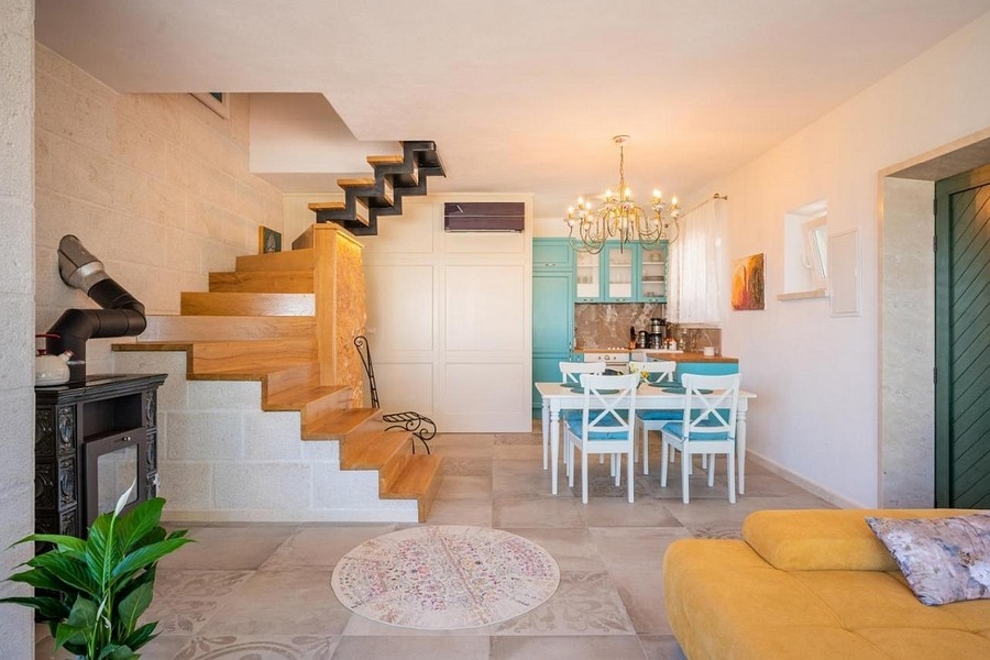 Obývací pokoj s otevřenou kuchyní a schodištěm v dalmatském stylu