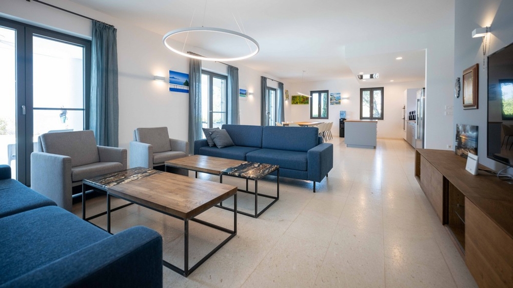 Světlý obývací prostor s velkými okny a otevřeným designem pokoje