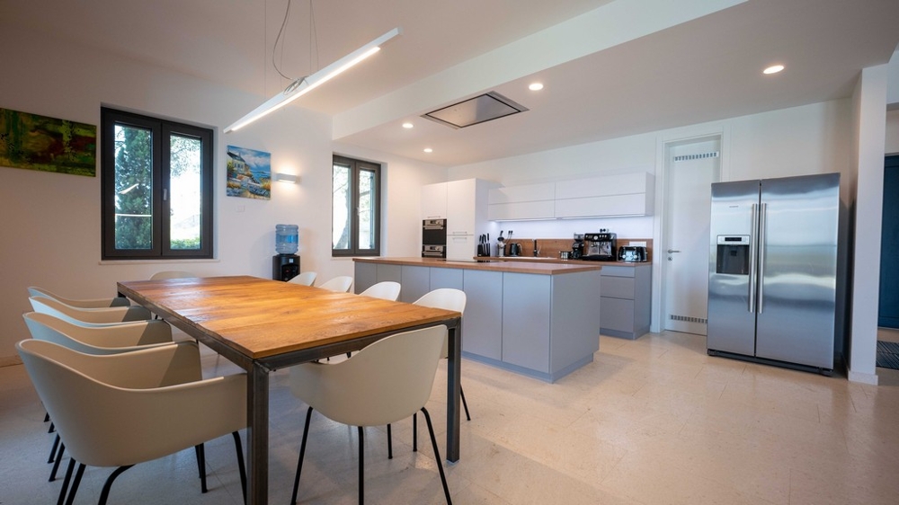 Moderní kuchyně s ostrůvkem na vaření a velkým jídelním stolem