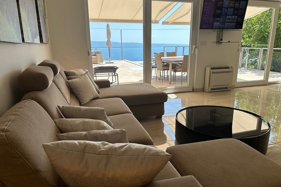 Obývací pokoj se vstupem na terasu a výhledem na moře