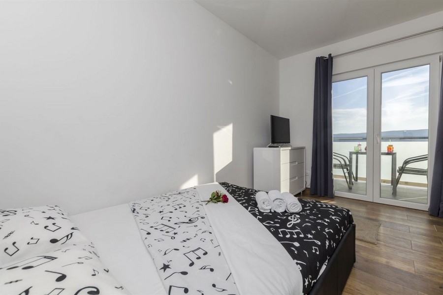 Ložnice se vstupem na balkon a výhledem na moře