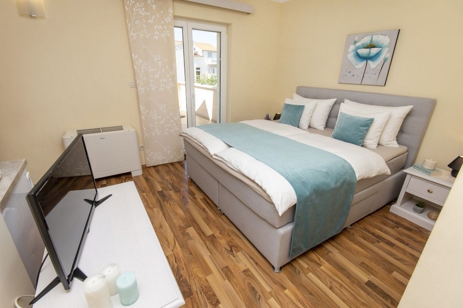 Ložnice s manželskou postelí a vstupem na balkon