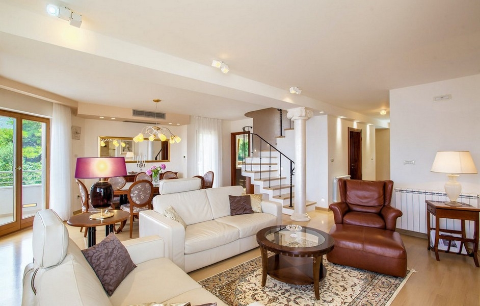 Světlý obývací pokoj s pohovkou a schodištěm