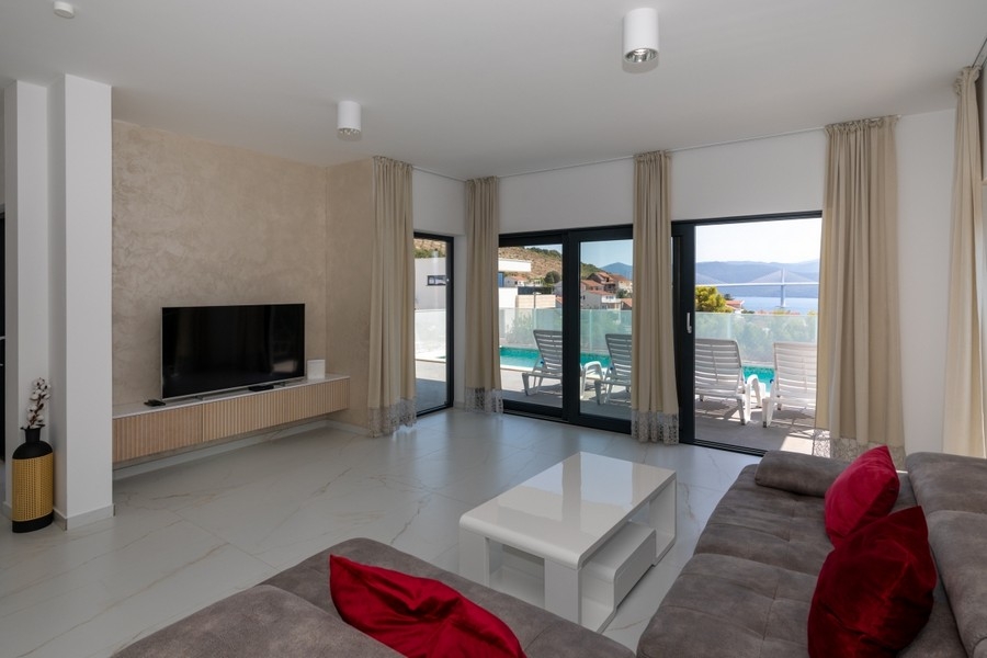 Moderní obývací pokoj se vstupem na terasu a bazén