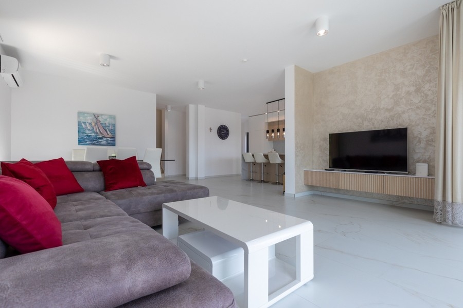 Prostorný obývací pokoj s pohovkou a TV