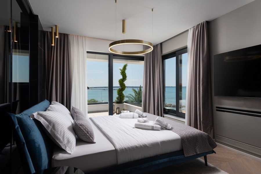 Ložnice s velkými okny a výhledem na moře v Chorvatsku