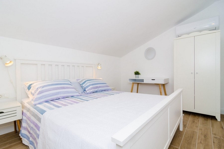 Světlá ložnice se zkoseným stropem