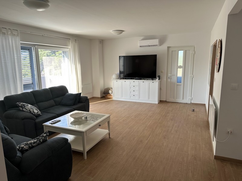 Obývací pokoj s pohovkou, TV a přístupem na balkon s moderním nábytkem