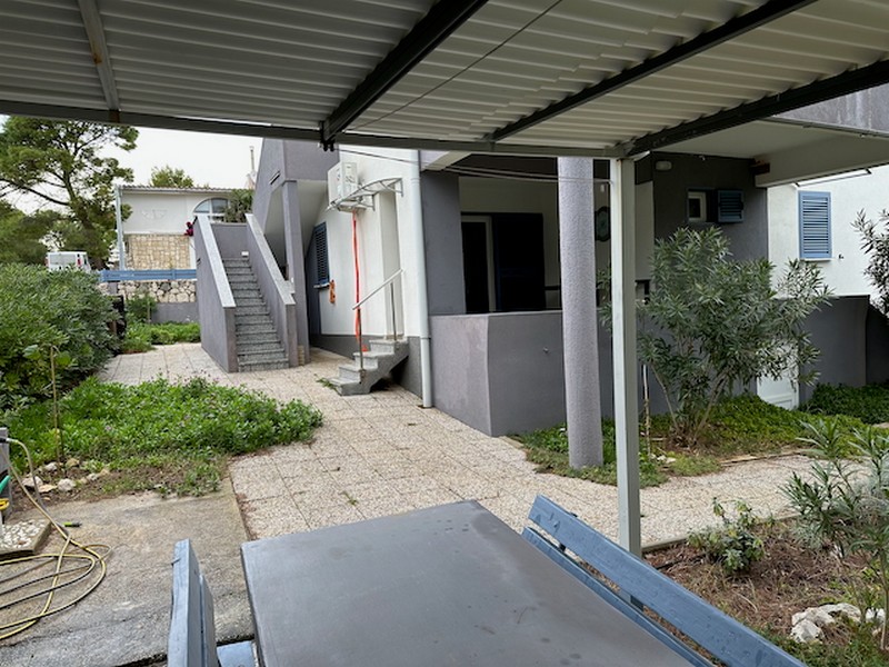 Venkovní plocha s terasou, pergolou a vstupem do bytových jednotek