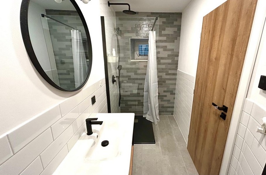 Koupelna se sprchovým koutem v úrovni podlahy a moderním vybavením