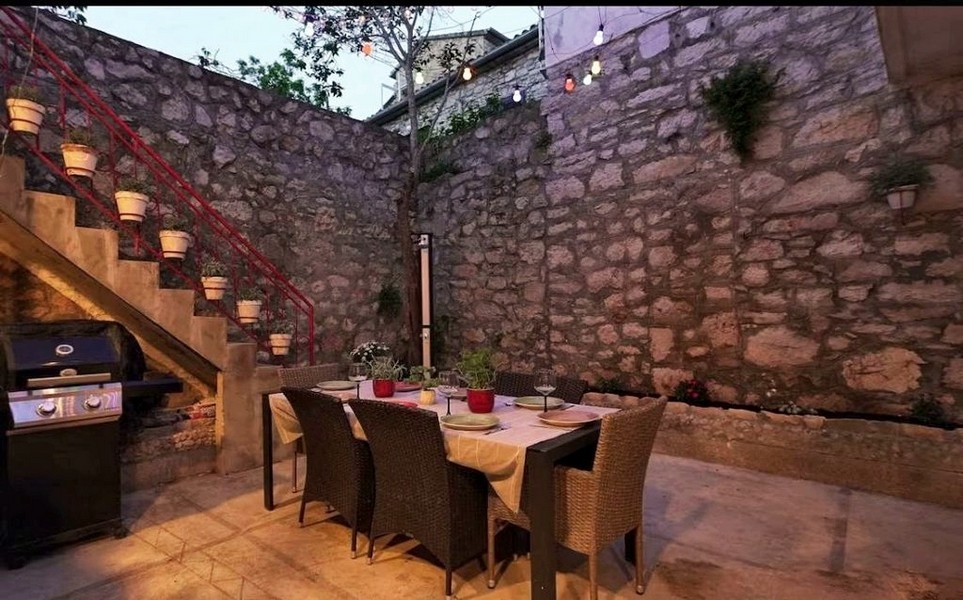 Vnitřní nádvoří s přírodní kamennou zdí a venkovním posezením