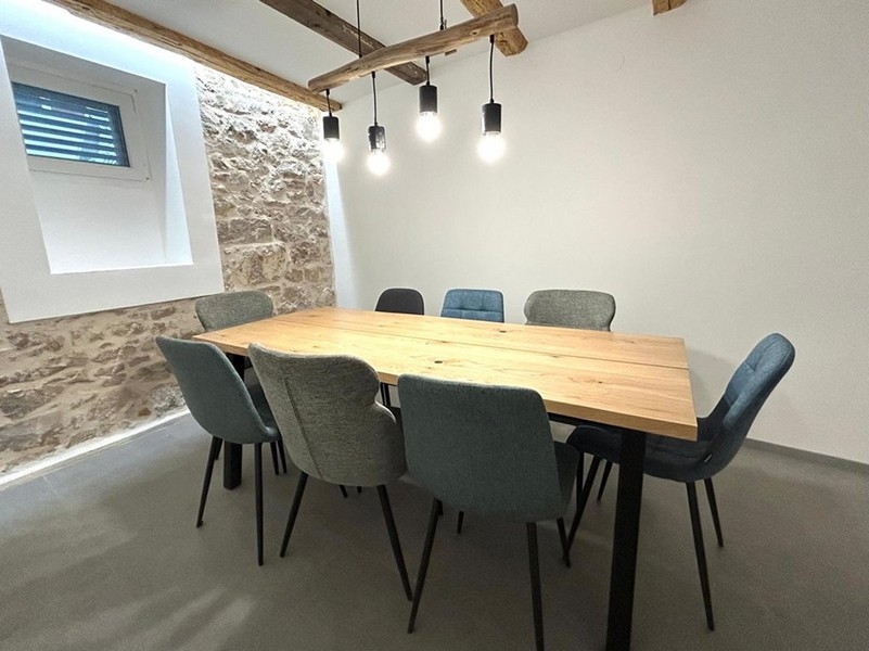 Vnitřní krytý jídelní kout s dřevěnými trámy a osvětlením