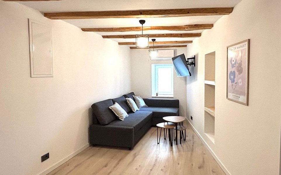 Obývací pokoj s pohovkou a trámovým stropem