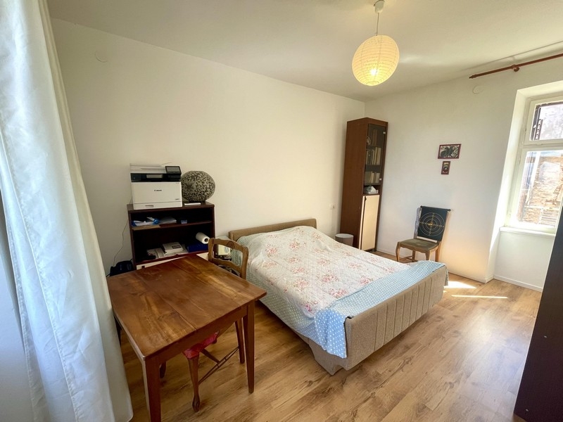 Ložnice s manželskou postelí a dřevěnou podlahou